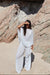 model in a chiffon bloom pant outfit standing next to a large rock formation.
